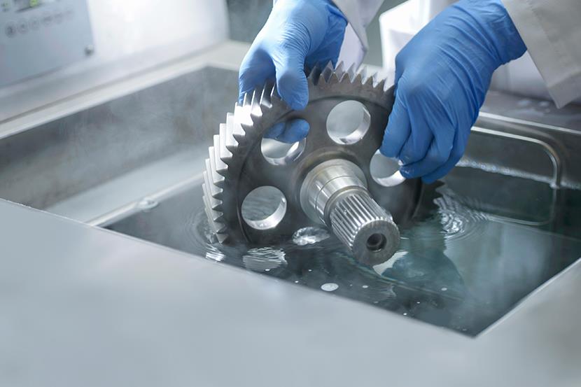 worker-wearing-blue-gloves-holding-gear-in-cleaning-liquid-1-4-6-1